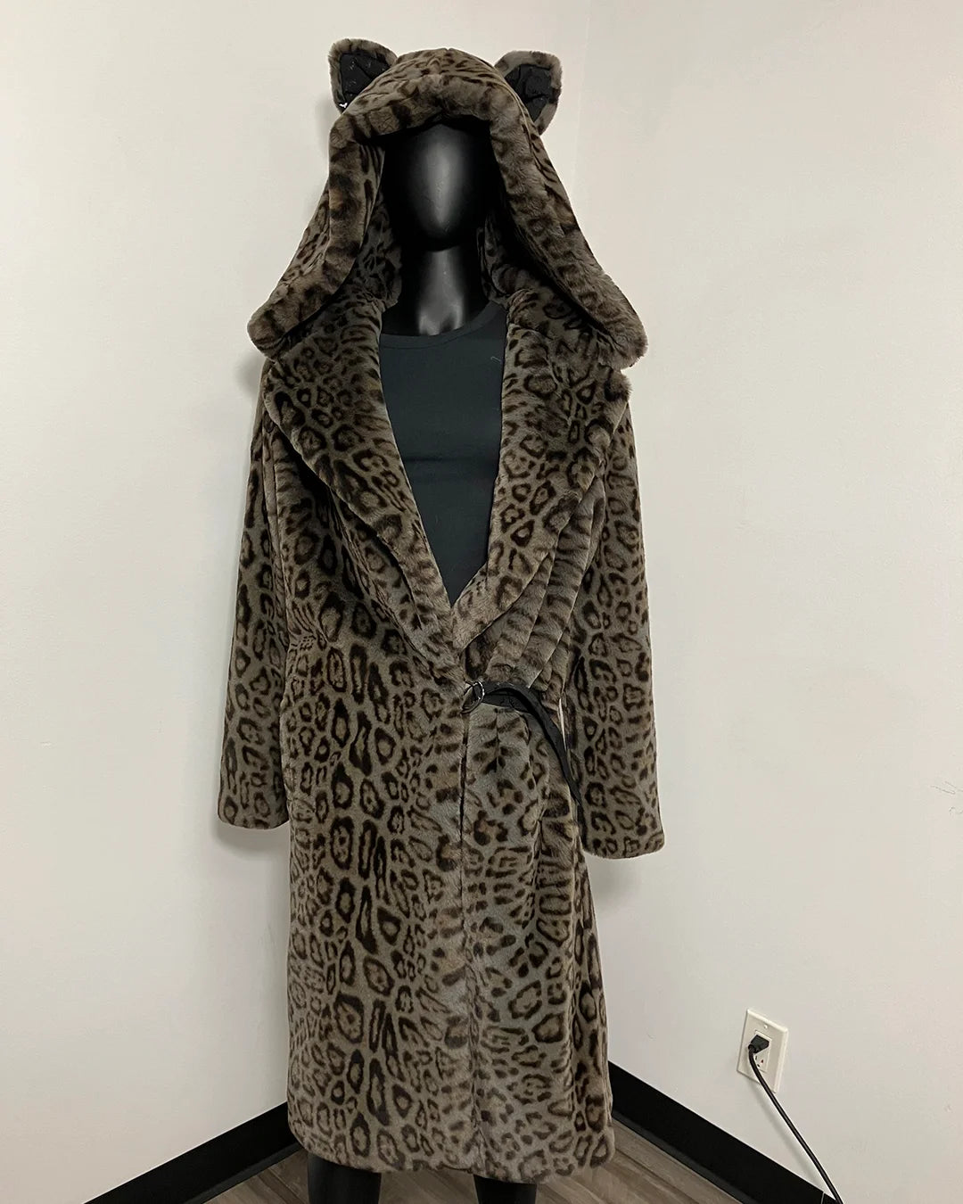 A leopard-print hooded robe with cat ears on the hood, displayed on a black mannequin against a plain white wall.