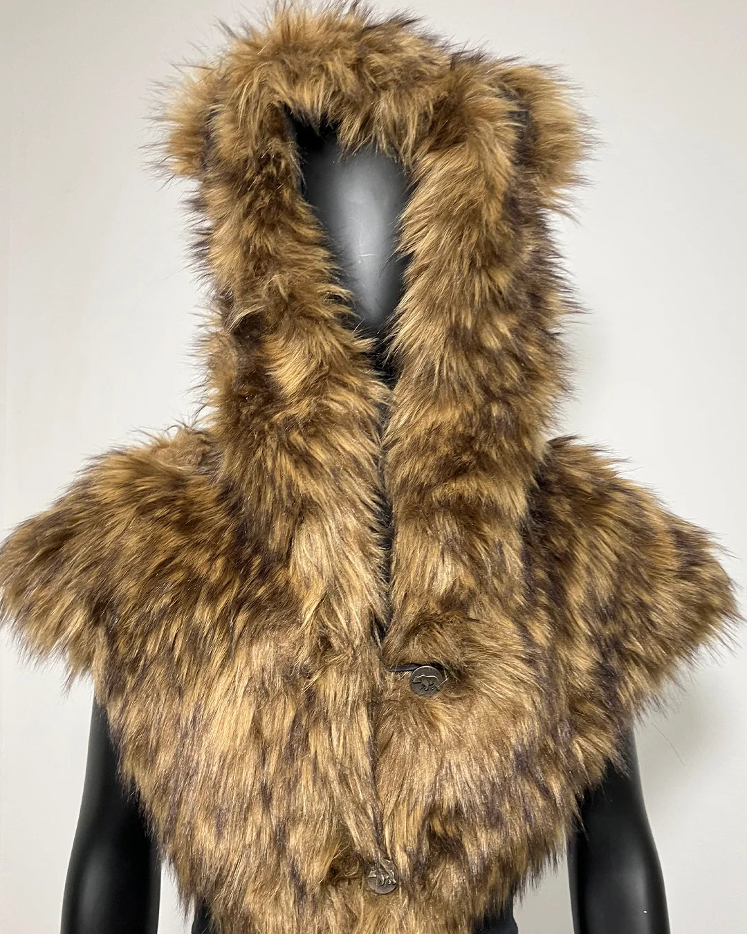 A brown and beige faux fur shawl with a faux fur hood and bear ears, displayed on a black mannequin against a plain light background.