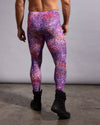 A man wearing purple and pink leopard-print festival leggings, shown from the back against a plain gray studio background.