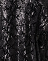 Close-up of shiny black sequin kimono fabric with a small reflective sequins.