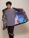 A man modeling a gray long-sleeve shirt and black ripped jeans, holding open a dark gray faux-fur trimmed coat that reveals a vibrant galaxy-print lining in shades of blue, purple, and pink.
