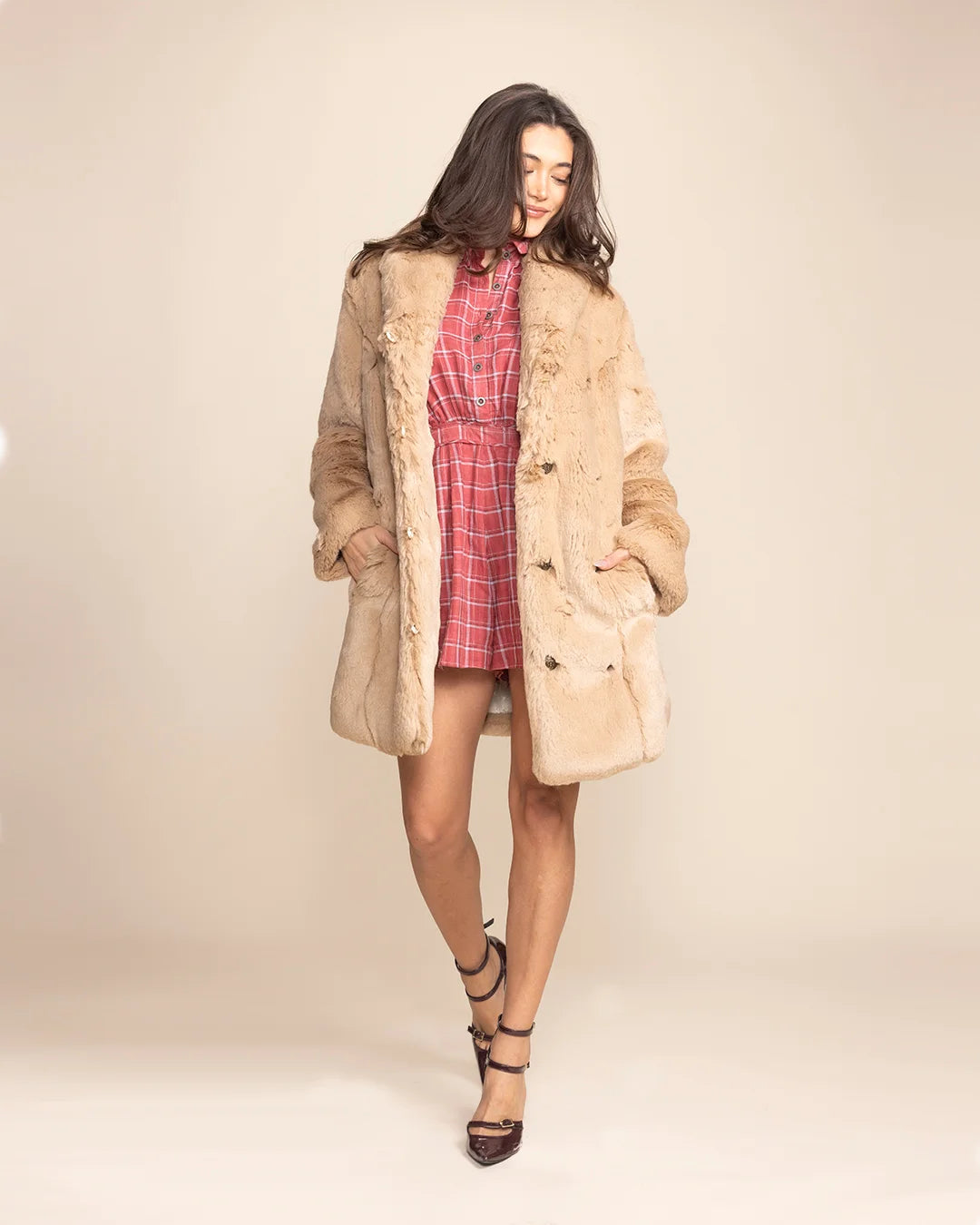 Woman wearing a tan Cougar faux fur coat featuring an oversized collar that can be worn up for down.