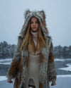 A Woman wearing a SpiritHoods Arctic Fox Fake Fur Jacket with an oversized hood and ears, in a snowy landscape