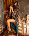 SpiritHoods Best Selling Grey Wolf Hooded Faux Fur Coat being worn as the model sprays herself with perfume and throws her head back to enjoy the smell and the outfit