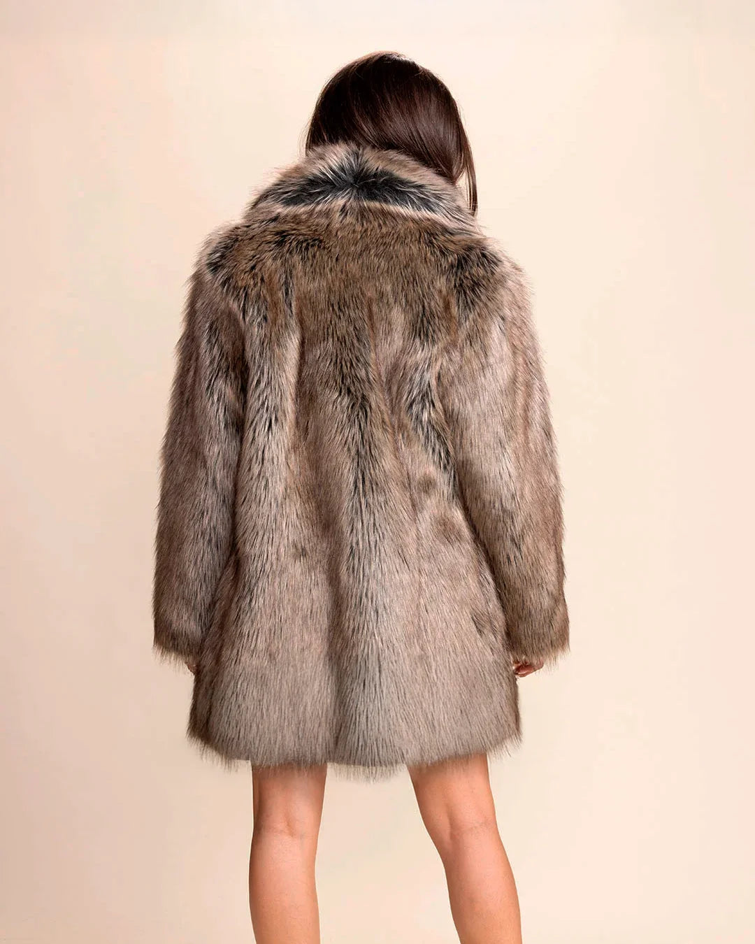 Back view of SpiritHoods Women's Faux Fur Coat in Dire Wolf fake Fur. Cruelty-free and vegan fashion worn by a person on a beige background