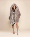 Woman wearing a Grey Fox hooded luxe faux fur coat with an oversized hood and plush grey fake fur.