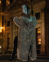 A Woman dressed as cruella deville looking away from the camera, wearing SpiritHoods Long Baby Snow Leopard Classic Floor Length Fake Fur Coat. Easy Halloween Costume Ideas. Halloween Outfits for Women