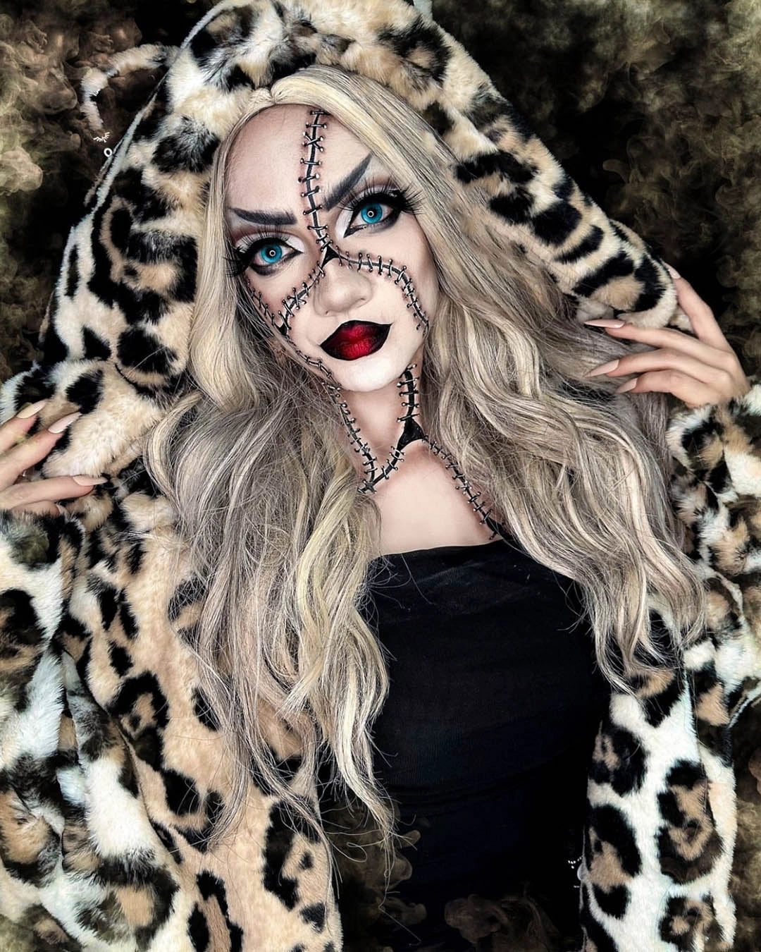 A Woman wearing SpiritHoods Arabian Leopard Classic Long Faux Fur Coat with over-sized stitching going over her face, nose and down her chest. Halloween Make Up Inspiration and Halloween Costume Ideas