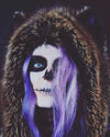 A Woman wearing SpiritHoods Dire Wolf Fake Fur hood with skull makeup and purple hair against a dark background. Halloween Make Up Halloween Costumes
