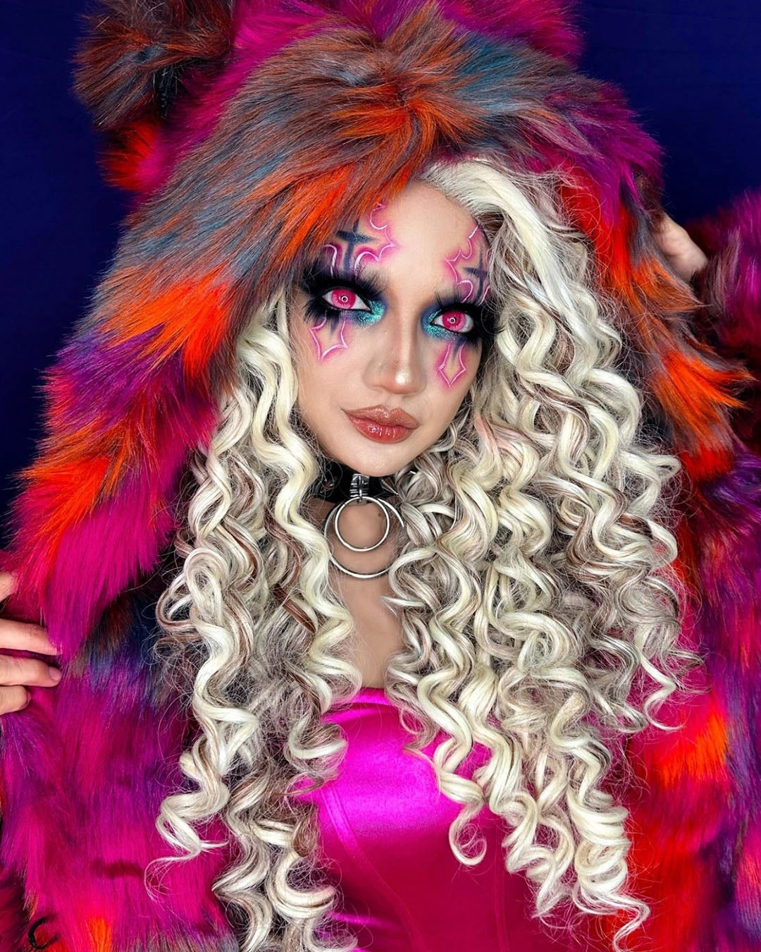 Woman with vibrant pop-art style crosses over her eyes with neon pink makeup and colorful SpiritHoods Collector Edition Calico Cat Fake Fur coat against a dark background. Easy Halloween Costume Ideas for Women, Halloween Outfits