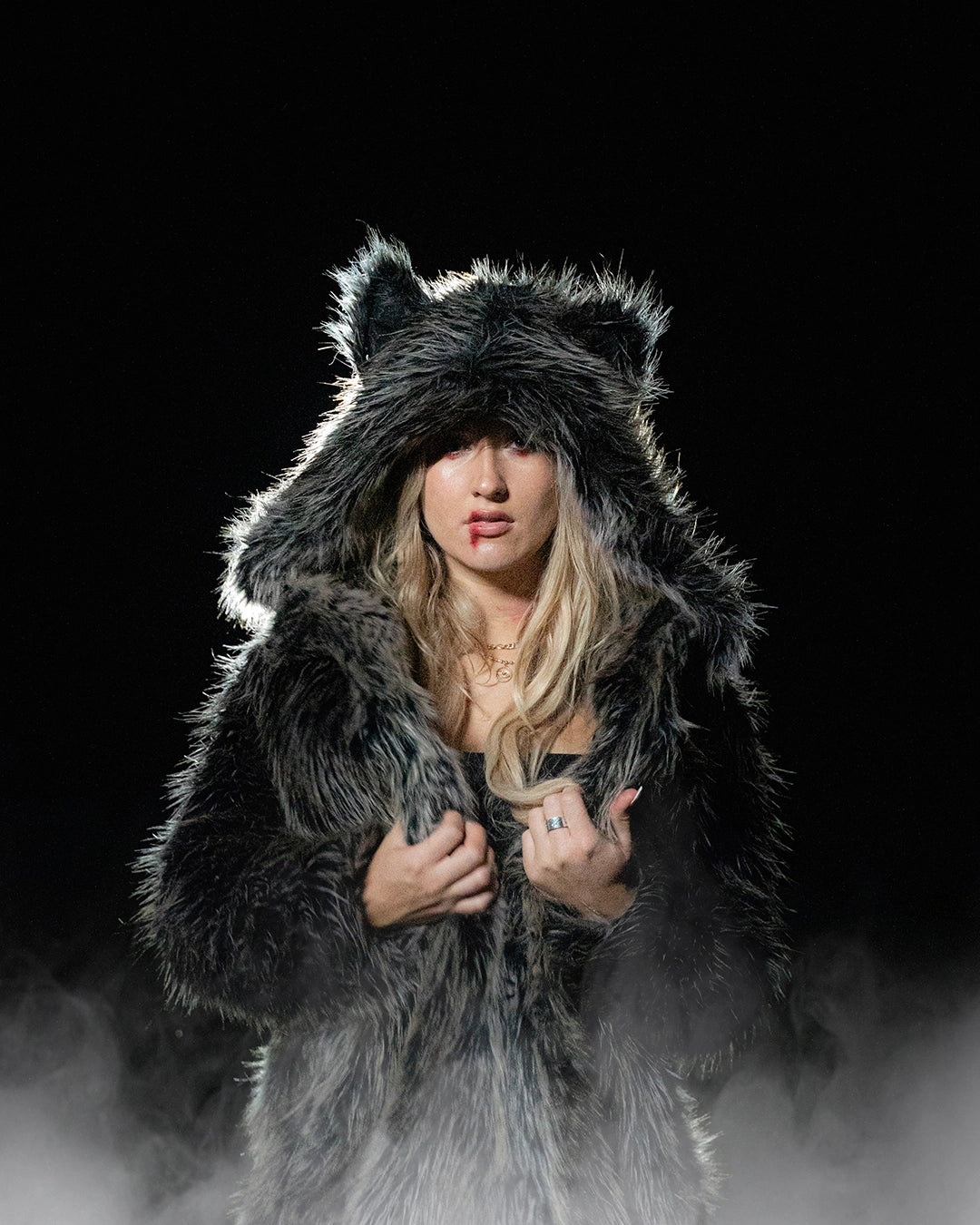 Woman wearing SpiritHoods Classic Grey Wolf Coat with fog coming up at the bottom, featuring easy halloween costume ideas with fake blood on one side of her mouth and red eyeshadow. SpiritHoods Halloween Costumes and Outfits