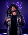 A Man wearing SpiritHoods Grey Wolf Hooded Fake Fur Jacket, with the hood on, holding the front, looking like hes having a great time! 