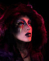A Woman wearing SpiritHoods Black Panther Coat with the Hood Up looking at the camera with fake contacts in making her eyes white, with gold and black make up. Easy halloween make up ideas. Halloween Costumes and Outfits