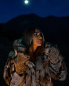 Woman in SpiritHoods best selling hooded wolverine fake fur coat under a full moonlit sky with mountains in the background. Halloween Costume Ideas. Halloween Outfits. Fall Fashion for Women