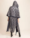 A Woman wearing a blue denim kimono leopard print kimono-robe with shimmering silver sequins sewn in throughout making leopard print on a beige background