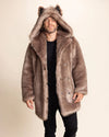 A Man smiling at the camera, wearing a brown faux fur coat as he walks forward. SpiritHoods relaxed fit men's fall/winter faux fur coats and jackets.