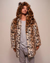 A man wearing a SpiritHoods leopard print coat made with plush fake fur, with a hood and ears, against a plain background. SpiritHoods Made to Order Faux Fur Coats and Animal print Custom Made Jackets