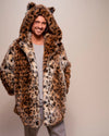 A Man wearing a leopard print fake fur jacket with an oversized hood adorned with feline ears, with his hands in the two outer coat pockets on a plain background. SpiritHoods Made To Order Leopard Print Fake Fur Coat for Men