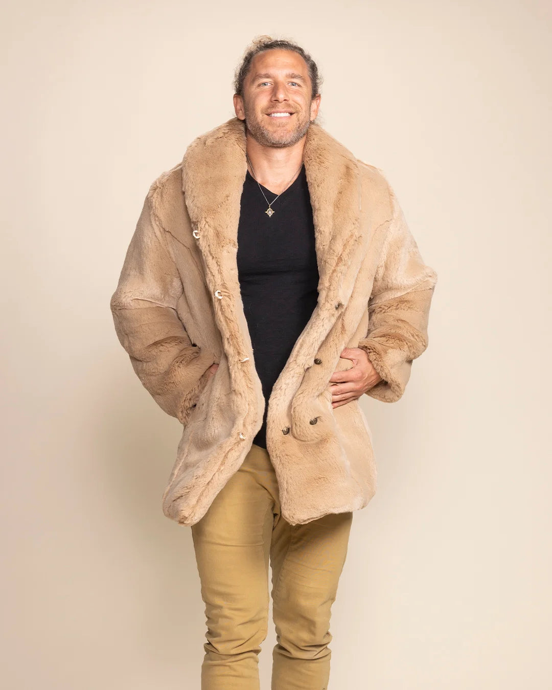 Man wearing a beige faux fur coat against a plain background. SpiritHoods Fall Winter Collection of Fake Fur Coats and Faux Fur Jackets for Men in Cougar