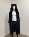 Mannequin wearing a black faux fur coat-robe with cat ears on a plain background