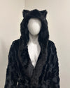 Black faux fur coat with cat ears on a mannequin against a plain background