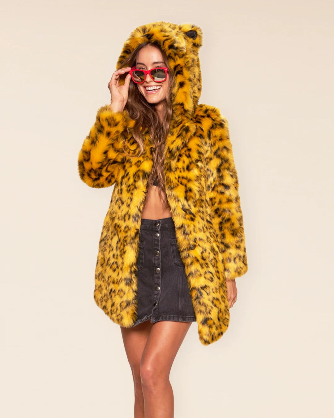 Front view of a woman in a Yellow Cheetah Classic coat featuring an oversized hood with ears and plush fur with classic feline animal print