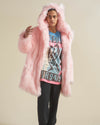 Person wearing a pink fur coat over a graphic t-shirt on a beige background