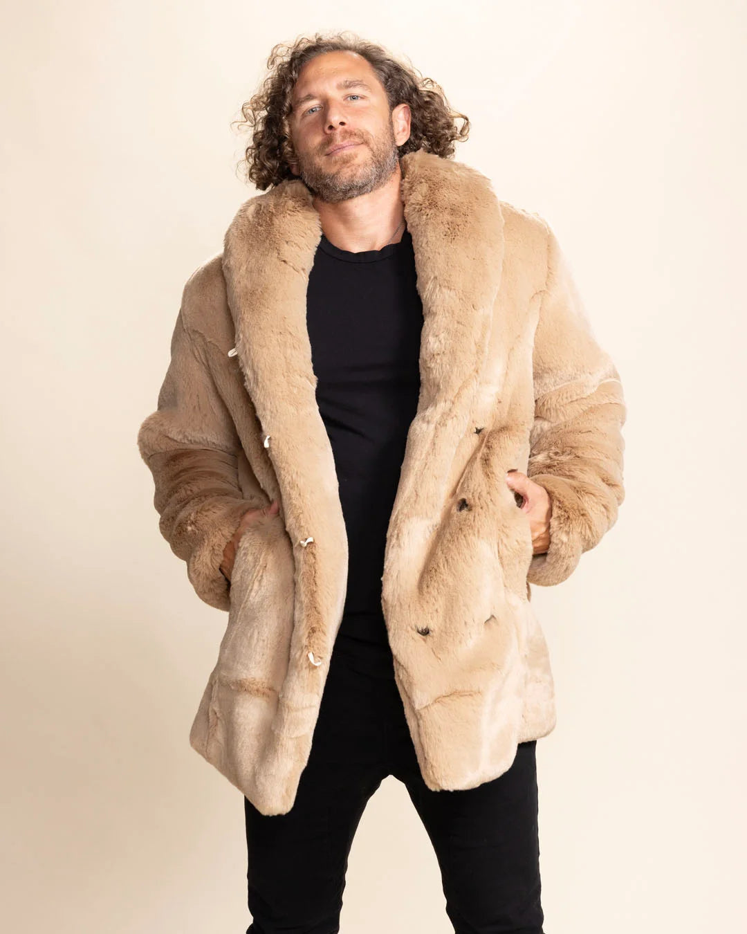 Man wearing a beige faux fur coat against a plain background. SpiritHoods Fall Winter Collection of Fake Fur Coats and Faux Fur Jackets for Men in Cougar