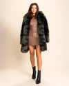 Woman wearing a thigh length multicolor green and brown fake fur jacket, with a neutral background. SpiritHoods Camo Cat Faux Fur Coat - Made to Order Fall Coat Collection.