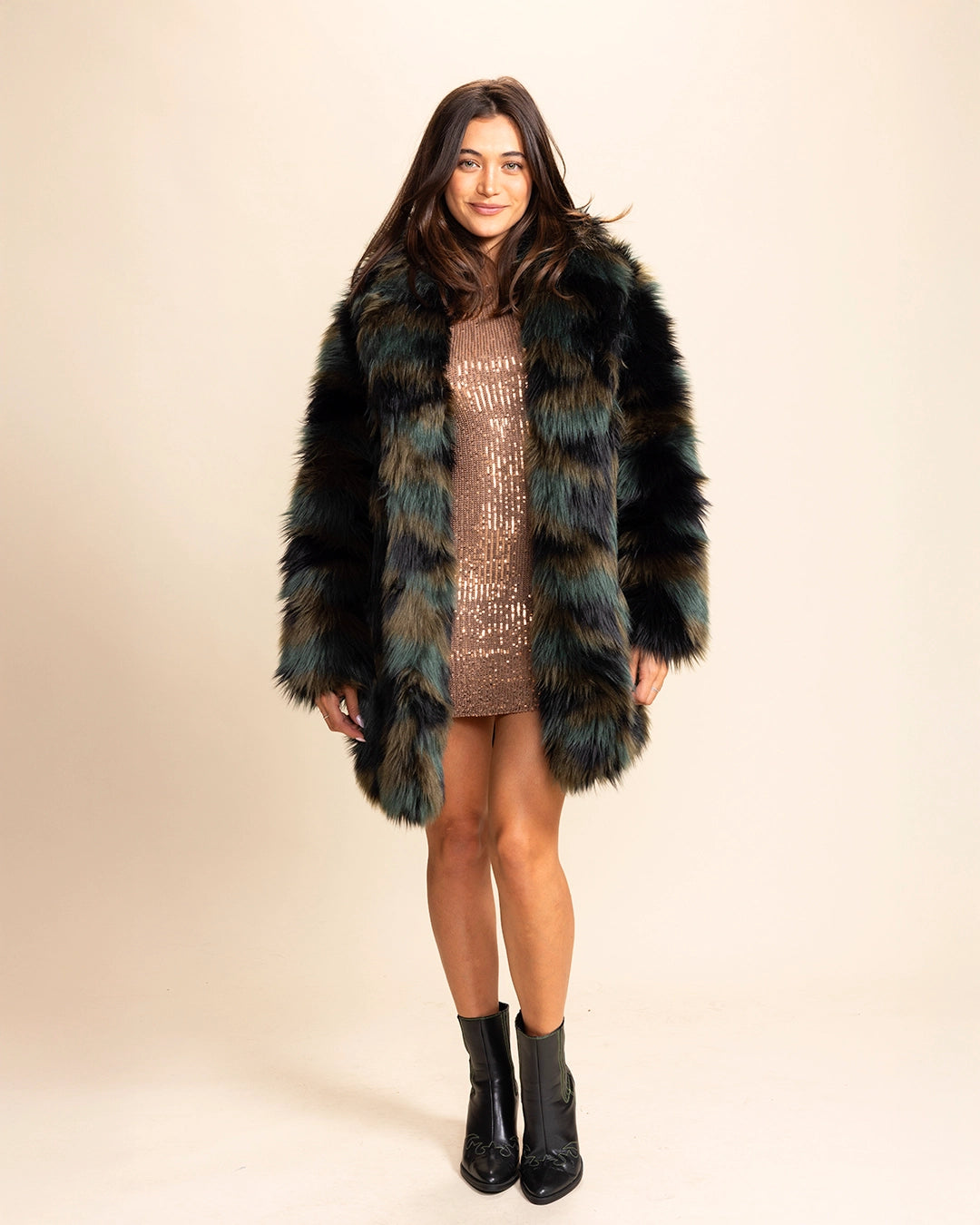 A Woman wearing a camoflage SpiritHoods green and brown fake fur coat on a beige background. Made To Order Coats and Fake Fur Custom Jackets For Women