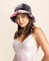 Woman wearing a colorful tie-dye pink and black bucket hat on a beige background