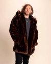 Men's brown fake fur jacket, cruelty-free, vegan fashion. Model is wearing the Hooded faux fur coat in Brown Wolf with the hood down, and his hands in the two outer pockets.