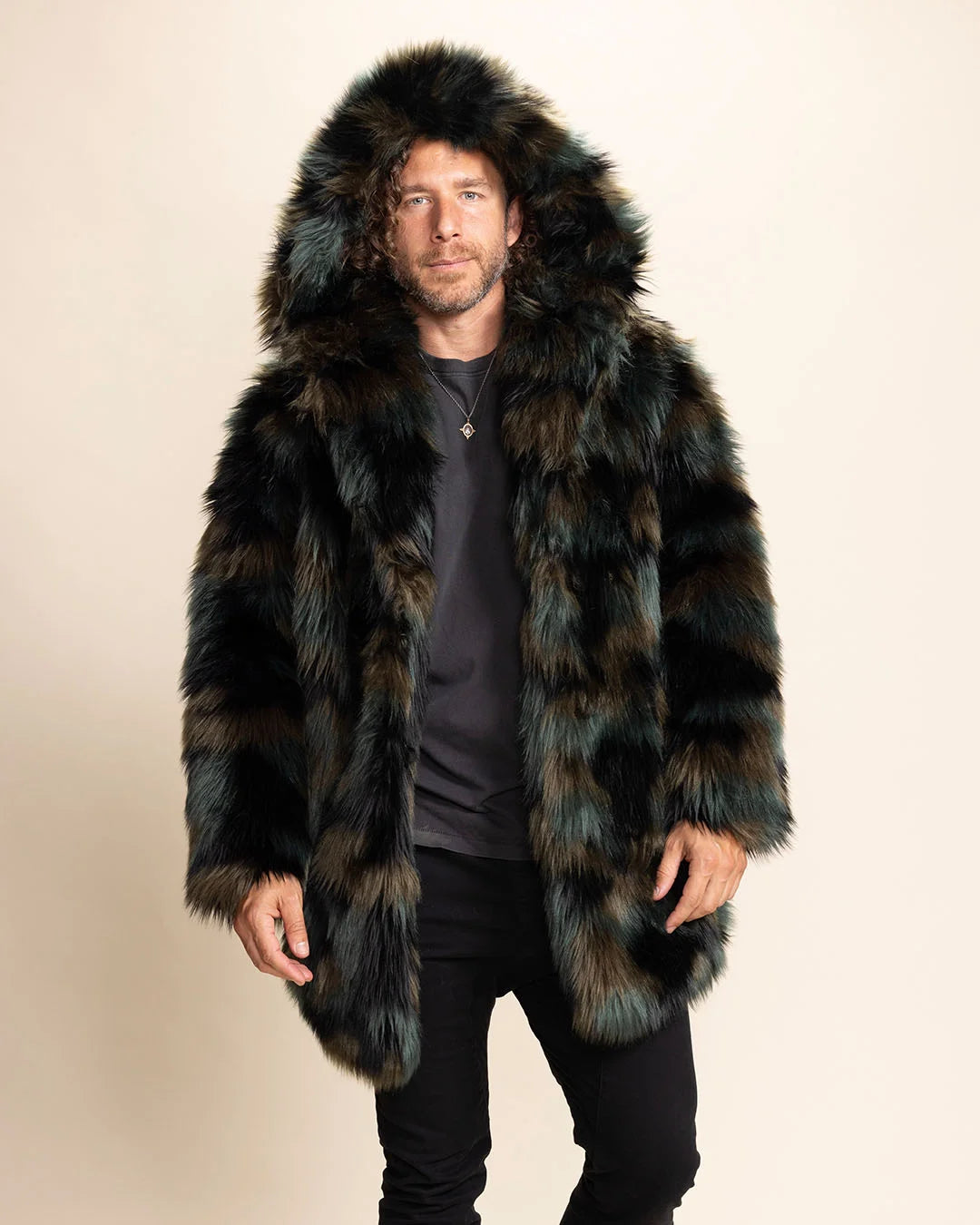 Man wearing a plush fake fur spirithoods coat with a large oversized hood on, smiling at the camera, on a beige background