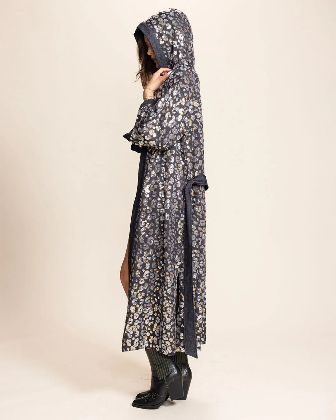 Women wearing a Denim Kimono with Hood and Belt-tie with shimmering silver and gold sequin leopard pattern on a beige background