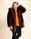 Man wearing a brown wolf inspired fake fur coat with the hood down, over an orange shirt on a beige background. SpiritHoods Fall Winter Custom made Fake Fur Coats and Animal Print Jackets