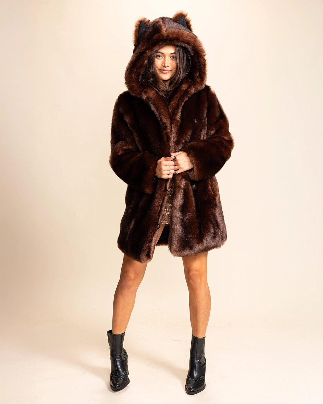 A Woman wearing a SpiritHoods Classic brown wolf faux fur coat with wolf ears on a beige background. SpiritHoods Fall Custom Faux Fur Coat Collection and Custom made Fake Fur Winter Jackets