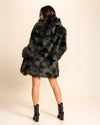 A Woman wearing a camoflage SpiritHoods green and brown fake fur coat on a beige background. Made To Order Coats and Fake Fur Custom Jackets For Women
