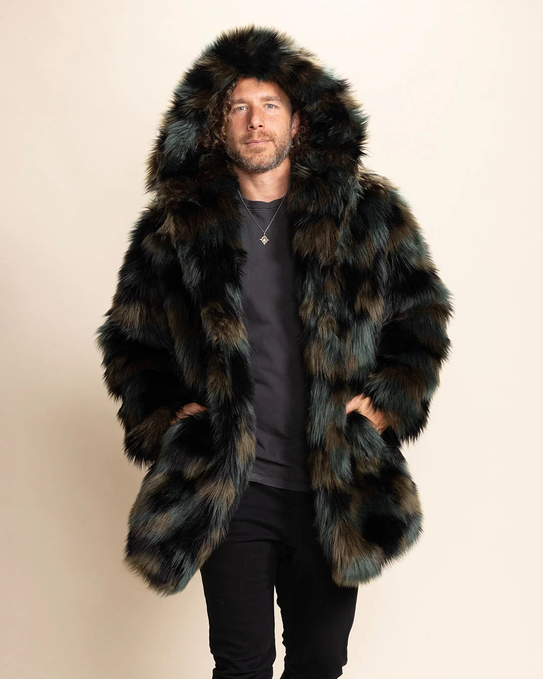Man wearing a camo colored fake fur coat with a hood on a beige background