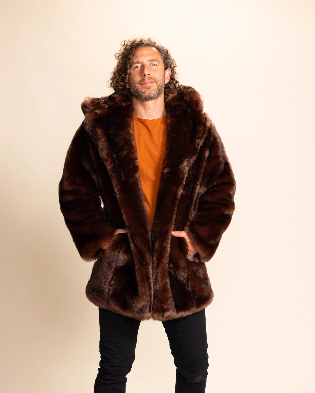 A Man wearing a brown fur free fur coat with wolf ears on a beige background. SpiritHoods Classic Faux Fur Coat in Brown Wolf with oversized hood and ears - Made to order limited waste fall winter coat collection.