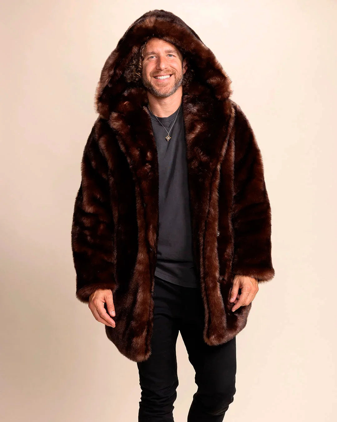 Man wearing a brown fake fur jacket on a beige background. Luxury festival-ready vegan faux fur coat.
