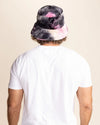 Person wearing a tie-dye bucket hat with pink and blue patterns on a beige background