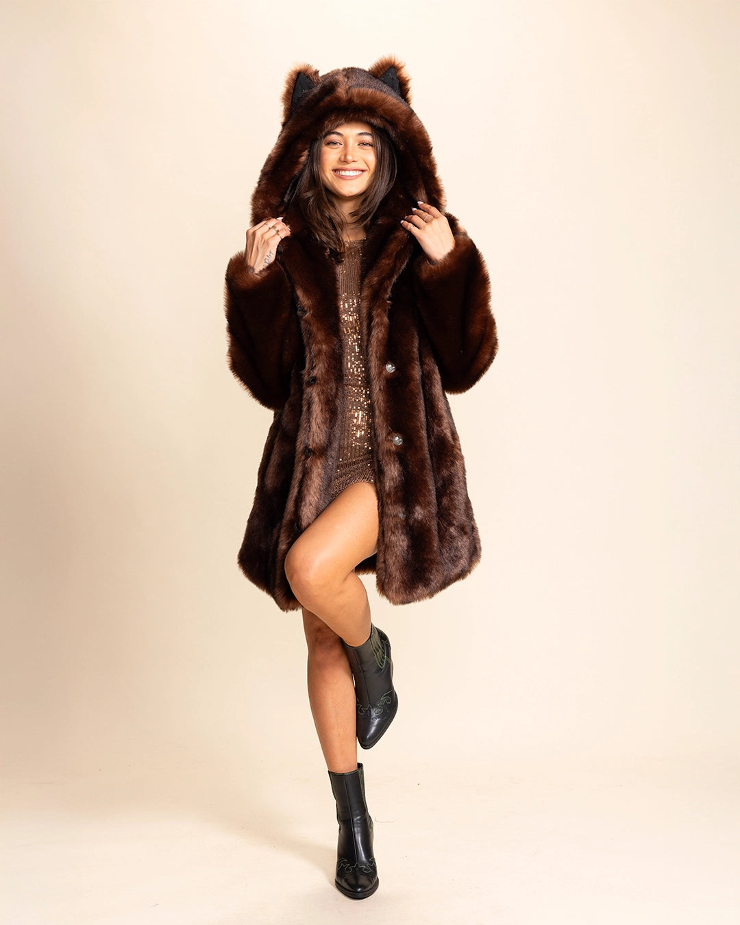 A Woman wearing a SpiritHoods Classic brown wolf faux fur coat with wolf ears on a beige background. SpiritHoods Fall Custom Faux Fur Coat Collection and Custom made Fake Fur Winter Jackets