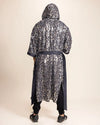 Person wearing a silver sequin leopard-patterned Kimono with hood and belt-tie on a beige background
