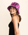 Woman wearing a pink and black animal patterned bucket hat on a beige background
