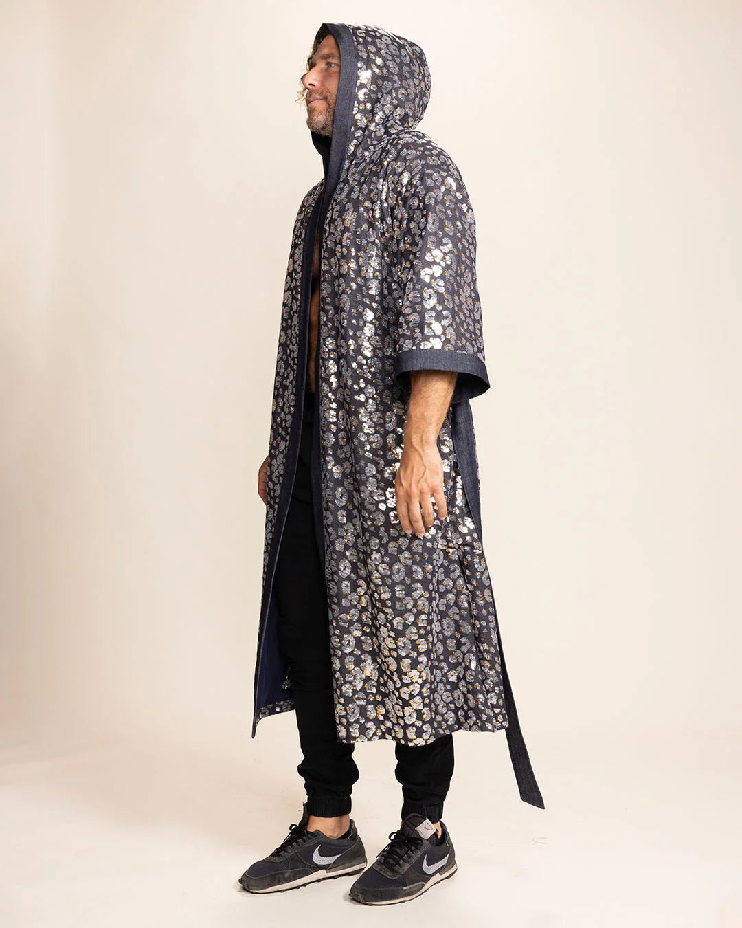 Person wearing a long, patterned leopard sequin print kimono-robe on a plain background