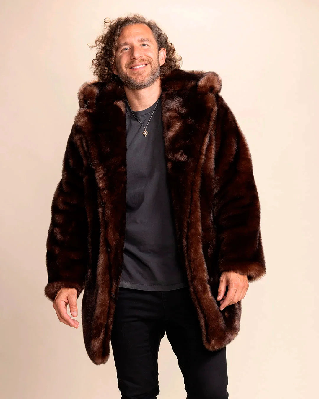 SpiritHoods Men's Hooded Faux Fur Coat in Brown Wolf. Vegan fake fur parka jacket for festivals, fall/winter layering. Model is facing the camera smiling with his arms folded infront of him, with the oversized hood up.