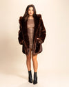 Woman wearing a SpiritHoods Classic Fake Fur Jacket with the hood down, and her hands in the two outer pockets, smiling at the camera.  Spirithoods cruelty free products- peta approved fake fur coats and custom made jackets