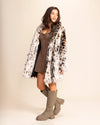Woman wearing a fur free fur cheetah coat and rain boots on a beige background. SpiritHoods Vegan Fashion Made to Order Faux Fur Coats for Women and Fake Fur Animal Print Jackets