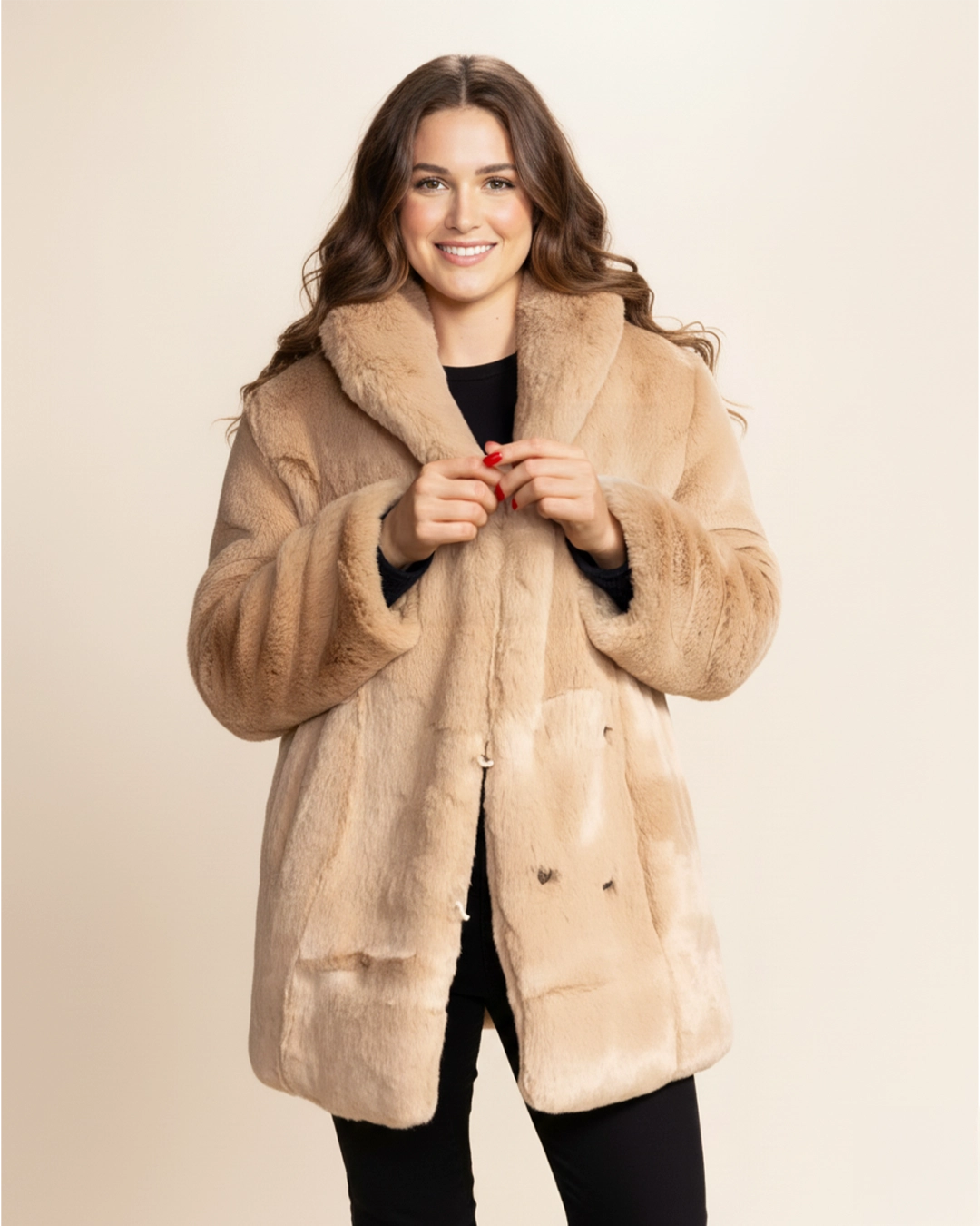 Woman wearing a beige fur free fur coat against a beige background. SpiritHoods 100% Beige Faux Fur Coat in Cougar featuring feline buttons and peacoat button closure and 4 functional pockets. SpiritHoods Fall Winter Coat Collection and Womens Fake Fur Jackets