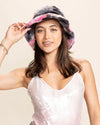Woman wearing a colorful tie-dye festival bucket hat with a plain background